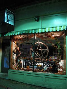 the front window of a store that is lit up with lights and decorations on display