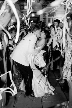 a bride and groom kiss as they are surrounded by confetti and streamers