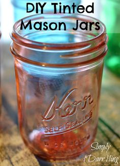 two mason jars sitting on top of a wooden table with text overlay that reads diy tinted mason jars