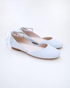 a pair of white shoes with pearls on them