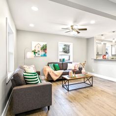 a living room filled with furniture and a ceiling fan