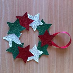 five red and green stars are arranged in a circle on top of a wooden table