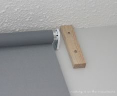 a close up of a roller on the wall with a wood beam attached to it