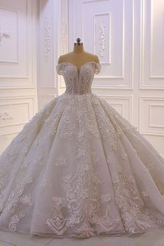 a wedding dress on display in a white room