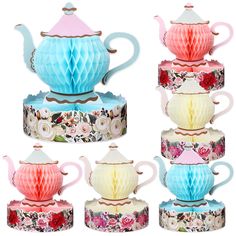 four teapots are stacked on top of each other with different designs and colors