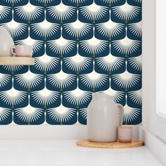 a white vase sitting on top of a counter next to a blue and white wall