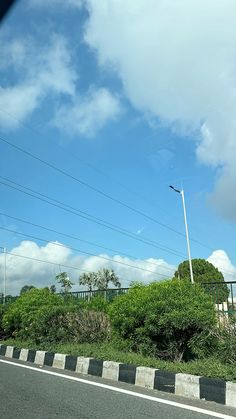 a street sign on the side of a road with power lines in the sky behind it