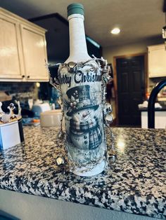 a wine bottle sitting on top of a kitchen counter covered in snowmen and frosting