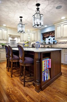 a kitchen with an island and chairs in it