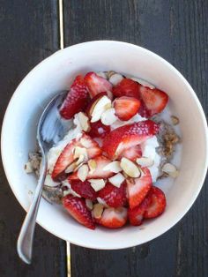 a bowl filled with yogurt, strawberries and almonds