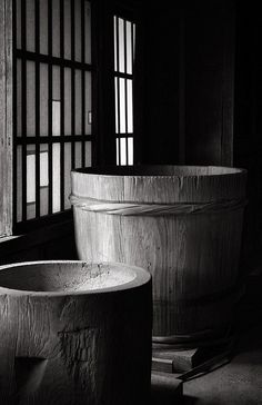 three large wooden buckets sitting next to each other in front of an open window