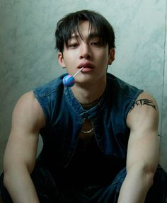 a young man sitting on the floor with an electric toothbrush in his mouth,