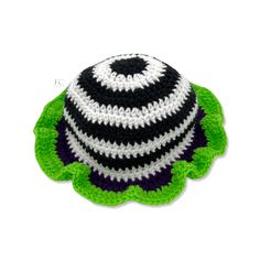 a crocheted turtle hat with black, white and green stripes