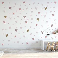 a child's room with pink and gold hearts on the wall