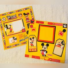 two mickey mouse photo frames are shown on a white sheeted surface with red and yellow trim