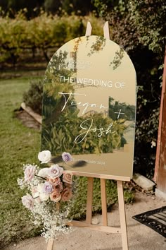 a wedding sign with flowers in front of it