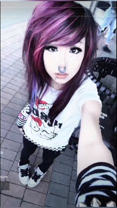 a girl with purple hair and piercings on her nose is posing for the camera