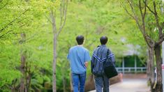 two people walking down a path in the woods