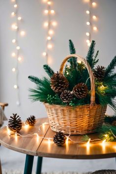 a basket filled with pine cones sitting on top of a wooden table next to christmas lights