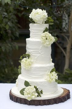 a wedding cake with white flowers and greenery