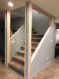 an empty room with stairs and carpeted flooring