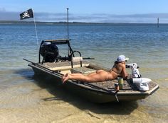 a woman laying on top of a boat in the water