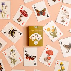 a card game with lots of cards on top of it and some butterflies flying around