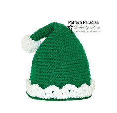 a crocheted green and white hat with pom - pom on top