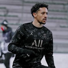 a man in black jersey holding a soccer ball