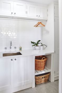 a kitchen with white cabinets and a basket in the corner next to the sink on the counter