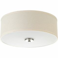 a white ceiling light with a beige shade on the bottom and an off - white drum