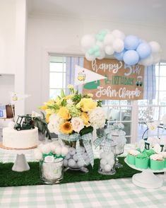 a table topped with lots of cakes and desserts on top of a checkered table cloth