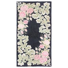 a black rug with pink flowers and leaves in the center, on a white background