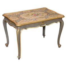 a small table with an ornate design on it's top and bottom half covered in flowers