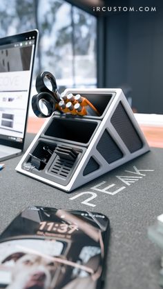 an open laptop computer sitting on top of a desk next to a pair of scissors