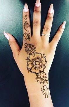 a woman's hand with henna tattoos on it