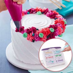 a woman is cutting into a cake with flowers on it and a pink knife in the middle