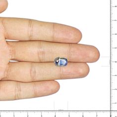 a person's hand with a ring on it and a ruler in the background