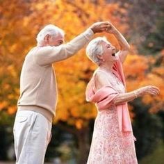 an older couple dancing in the park