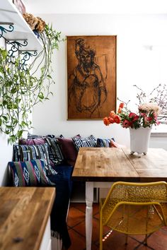 a wooden table sitting under a painting on the wall