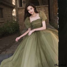 a woman in a green dress posing for the camera