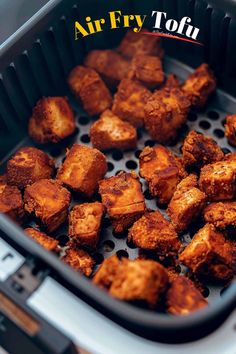 some fried food in a black container on top of a table with the words air fry tofu above it