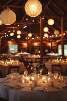 the tables are set with white linens and lit candles