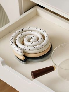 a glass bowl sitting on top of a counter next to a white snake and other items