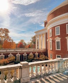 the sun shines brightly in front of a brick building with columns and arches on it