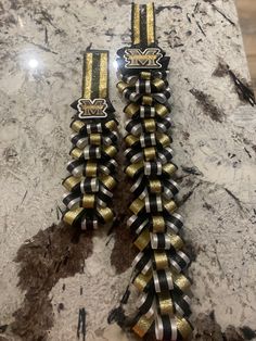 two black and gold ribbon clips on a marble counter