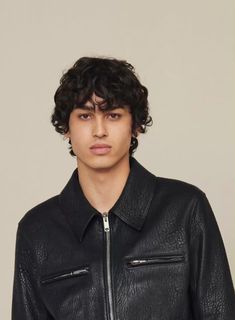 a young man wearing a black leather jacket