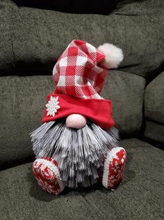 a red and white gnome sitting on top of a couch