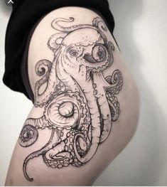 an octopus tattoo on the side of a woman's thigh