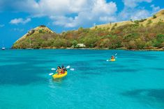 two people are kayaking in the clear blue water